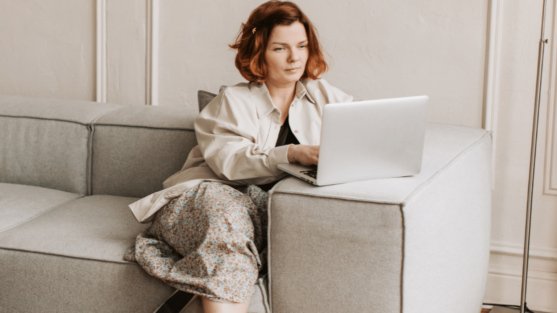 Kvinna arbetar på laptop i soffan