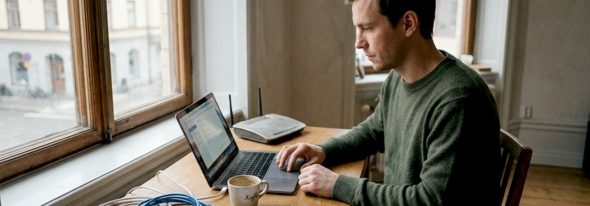 Man arbetar vid dator i hemmet.